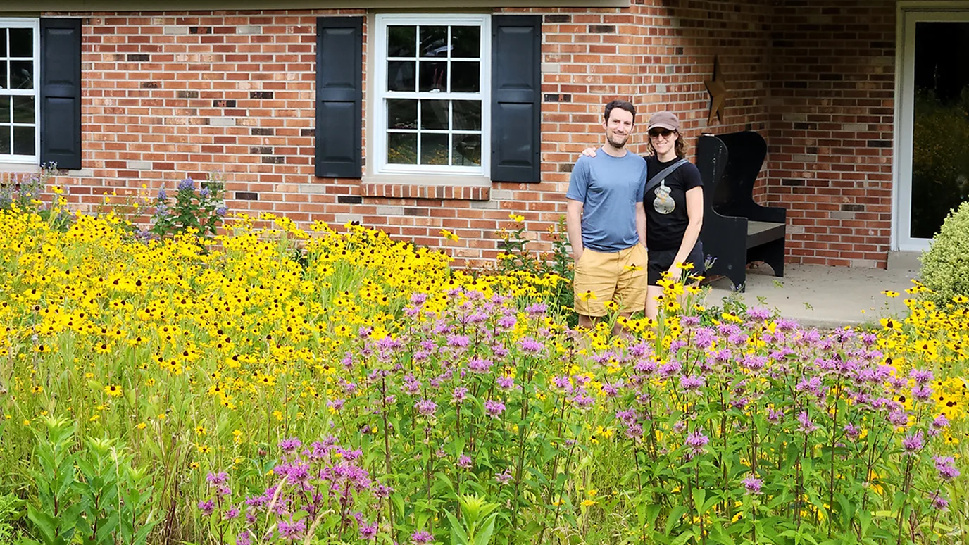 Sara Weaner Cooper and her husband standing in their front yard meadow in Pennsylvania